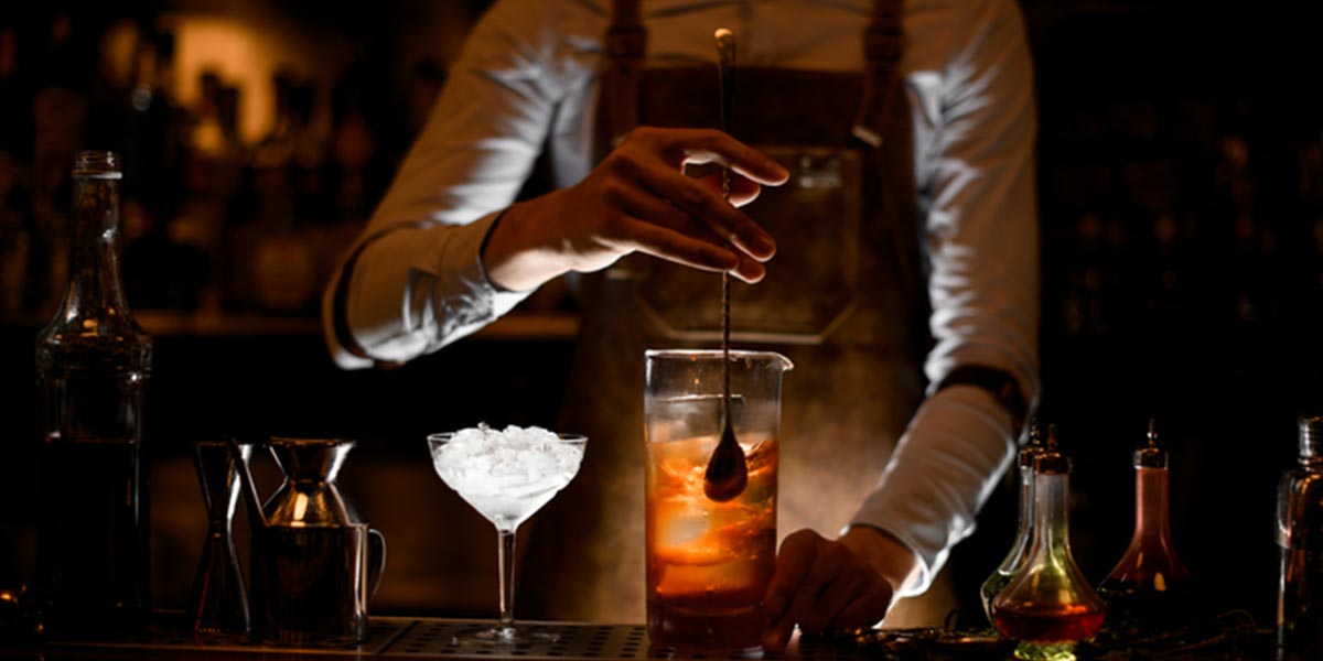 Bartender stirring alcohol cocktail with a spoon