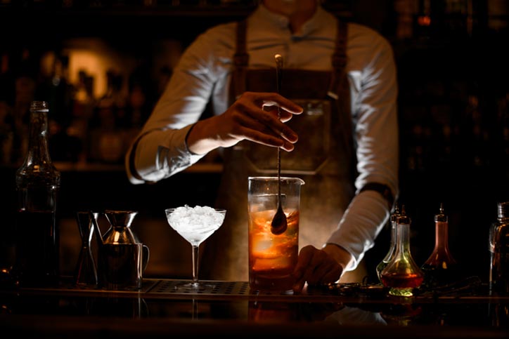 Bartender stirring alcohol cocktail with a spoon