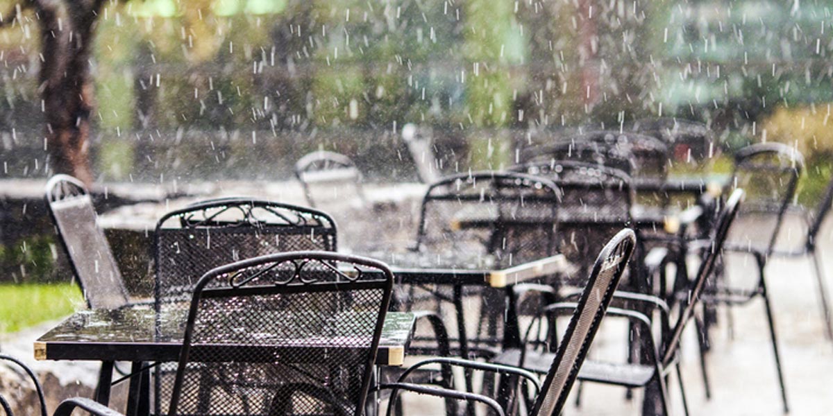 Rain falling on restaurant tables